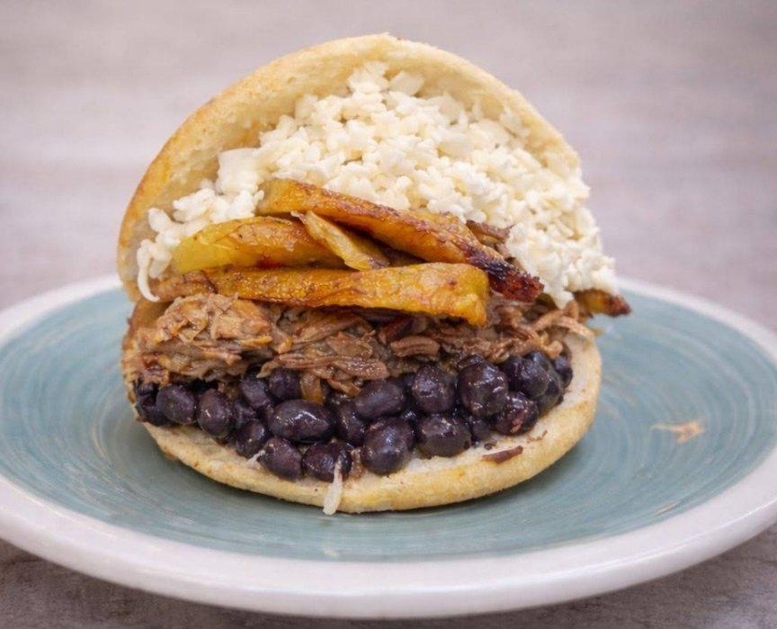 Arepa rellena de carne mechada, frijoles y queso