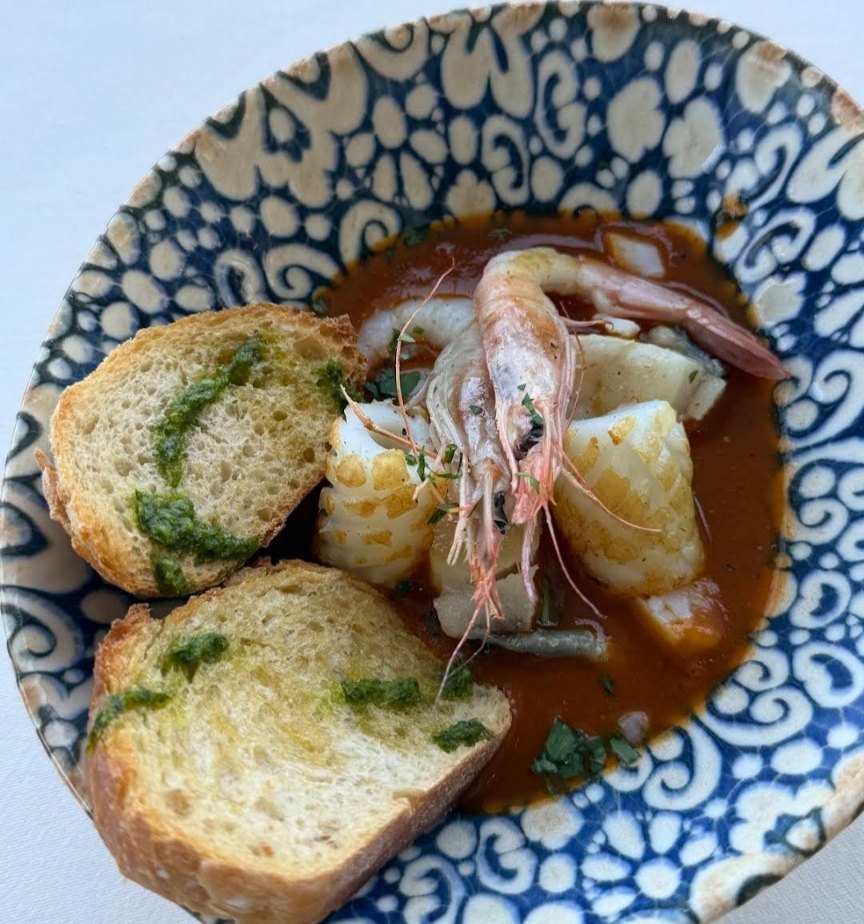 Guiso de marisco con pan y aceite de perejil