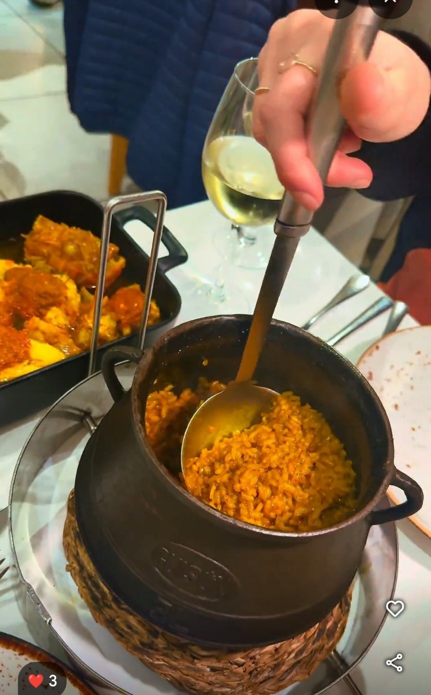Arroz caldoso servido en olla de hierro