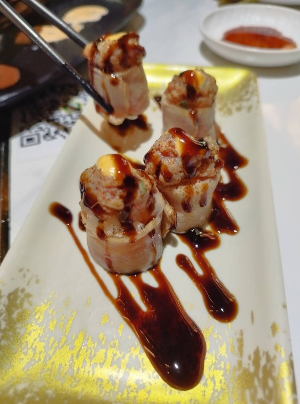 Rollen mit dicker Sauce und cremigem Topping, im Runden-System serviert
